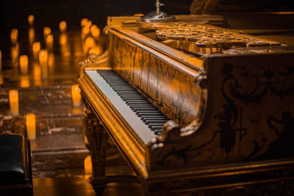 a photo of a grand piano illuminated by candlelight