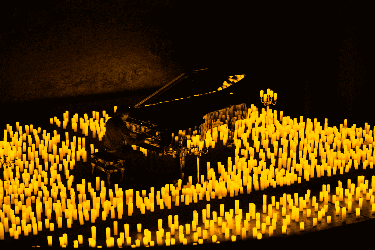 A pianist plays in a sea of candles