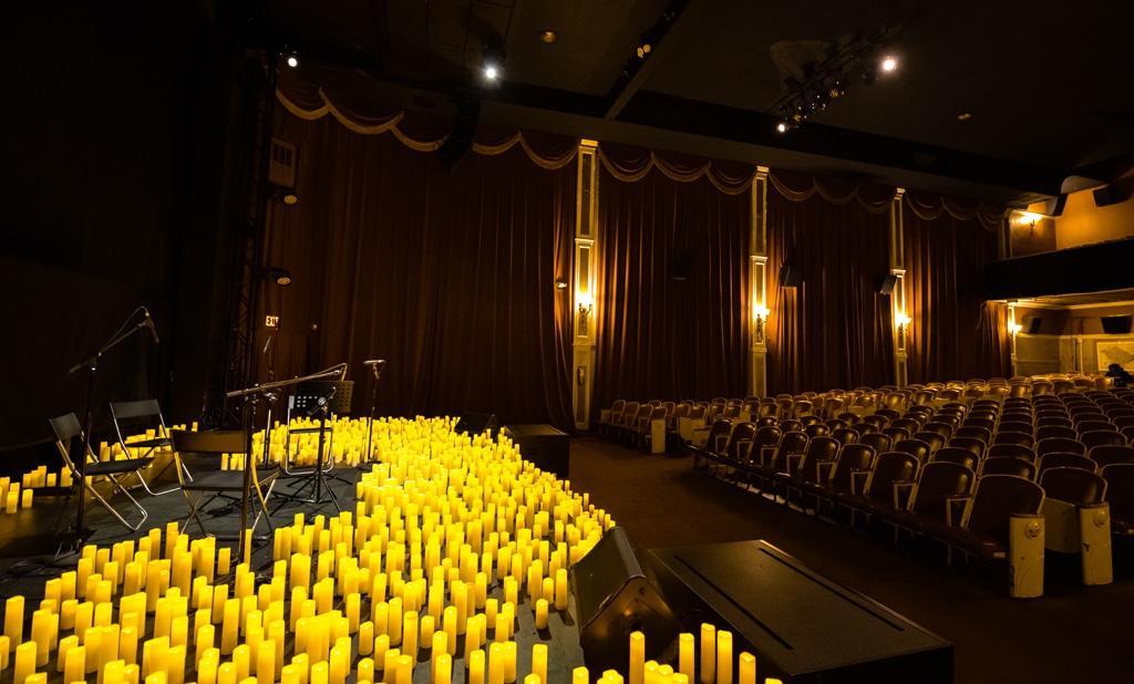 A stage set up for a Candlelight concert covered in candles at The Miracle Theatre