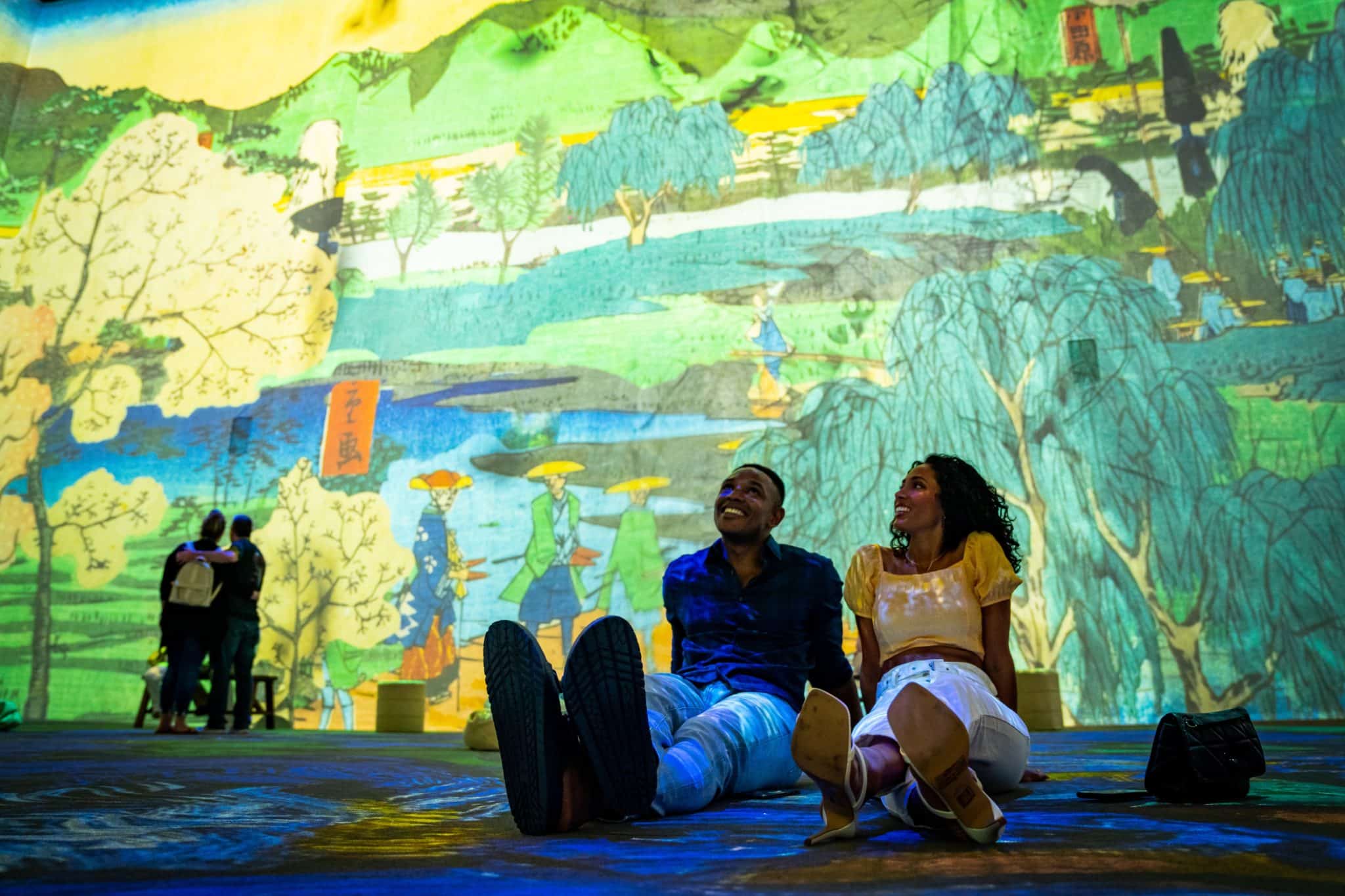duo sitting on the floor looking at the Van Gogh art projections