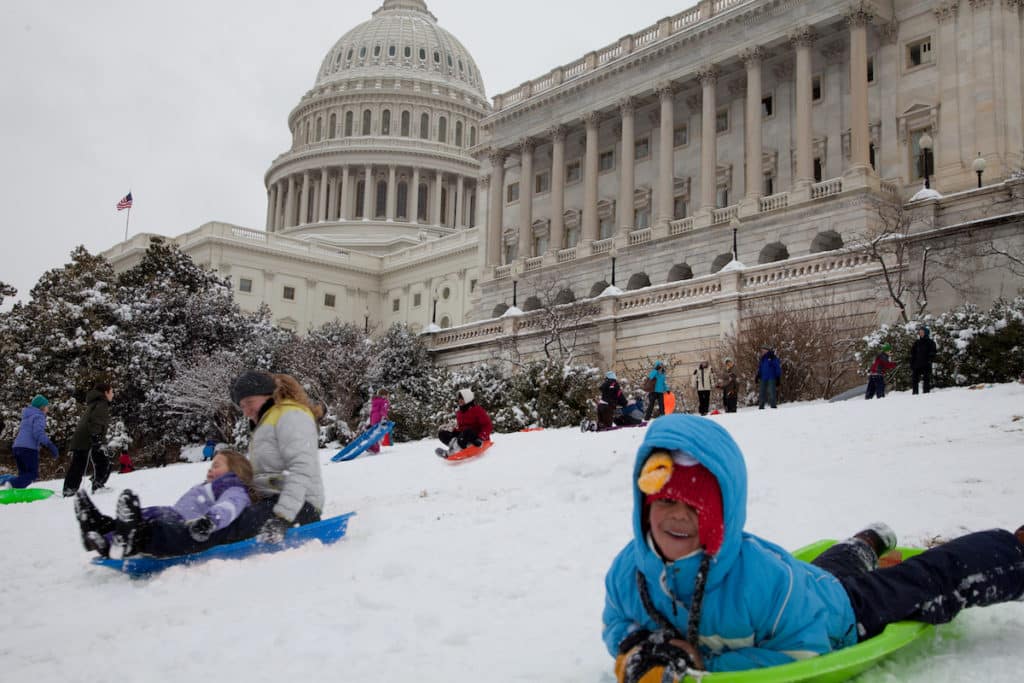 WASHINGTON, DC - MARCH 17: Unexpected snow day on March 17, 2014 in Washington, DC. Schools were closed, children and adults are playing with their snow sled on the US Capitol lawn.