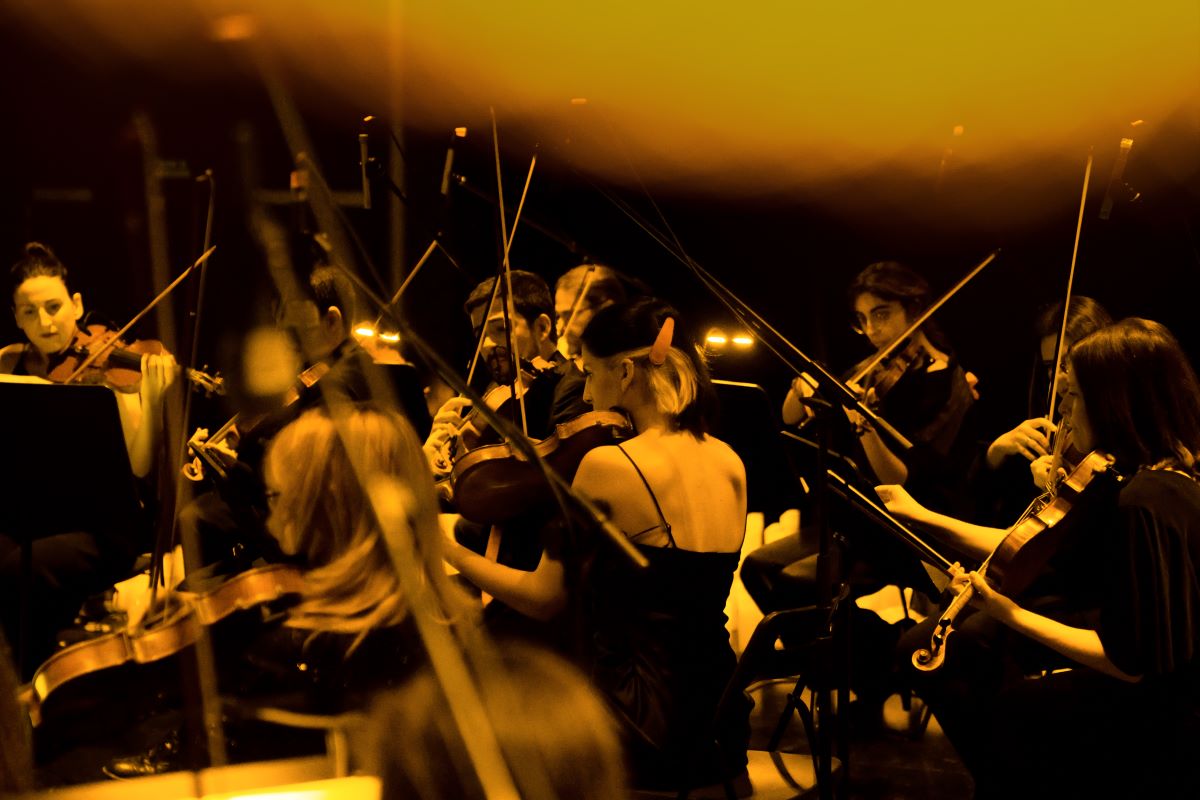 A Candlelight orchestra performing on violins at a Candlelight concert.