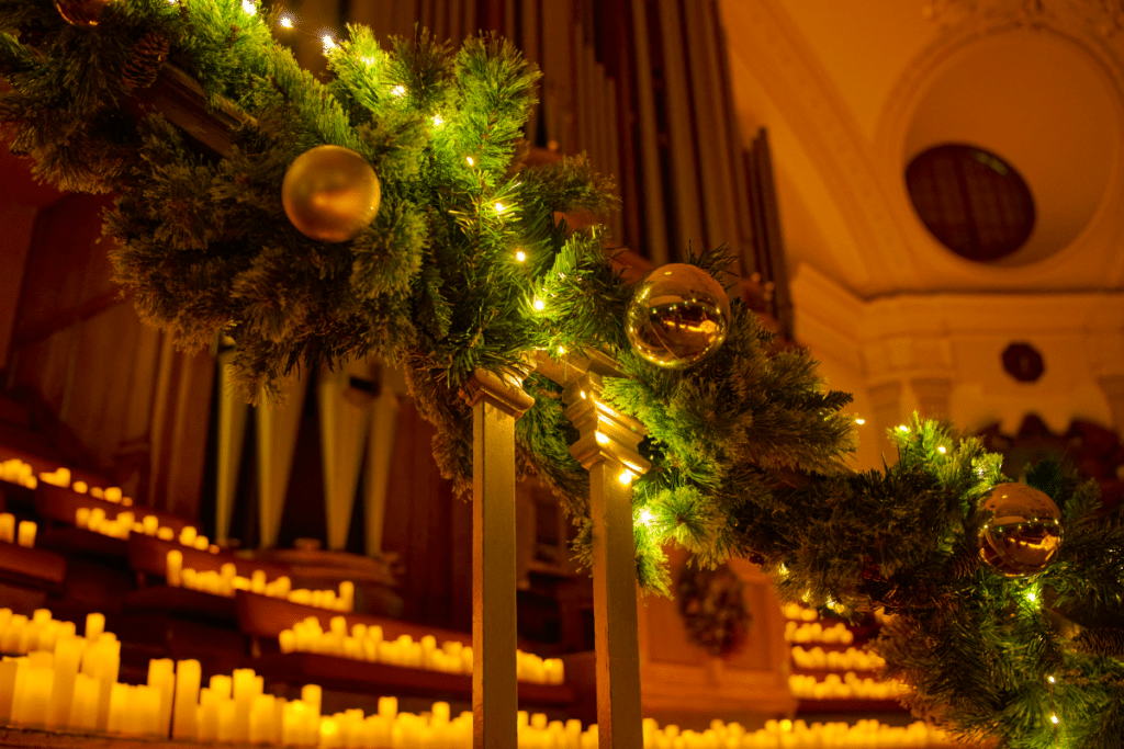 A staircase adorned with hundreds of candles and a Christmas wreath for the Candlelight holiday series